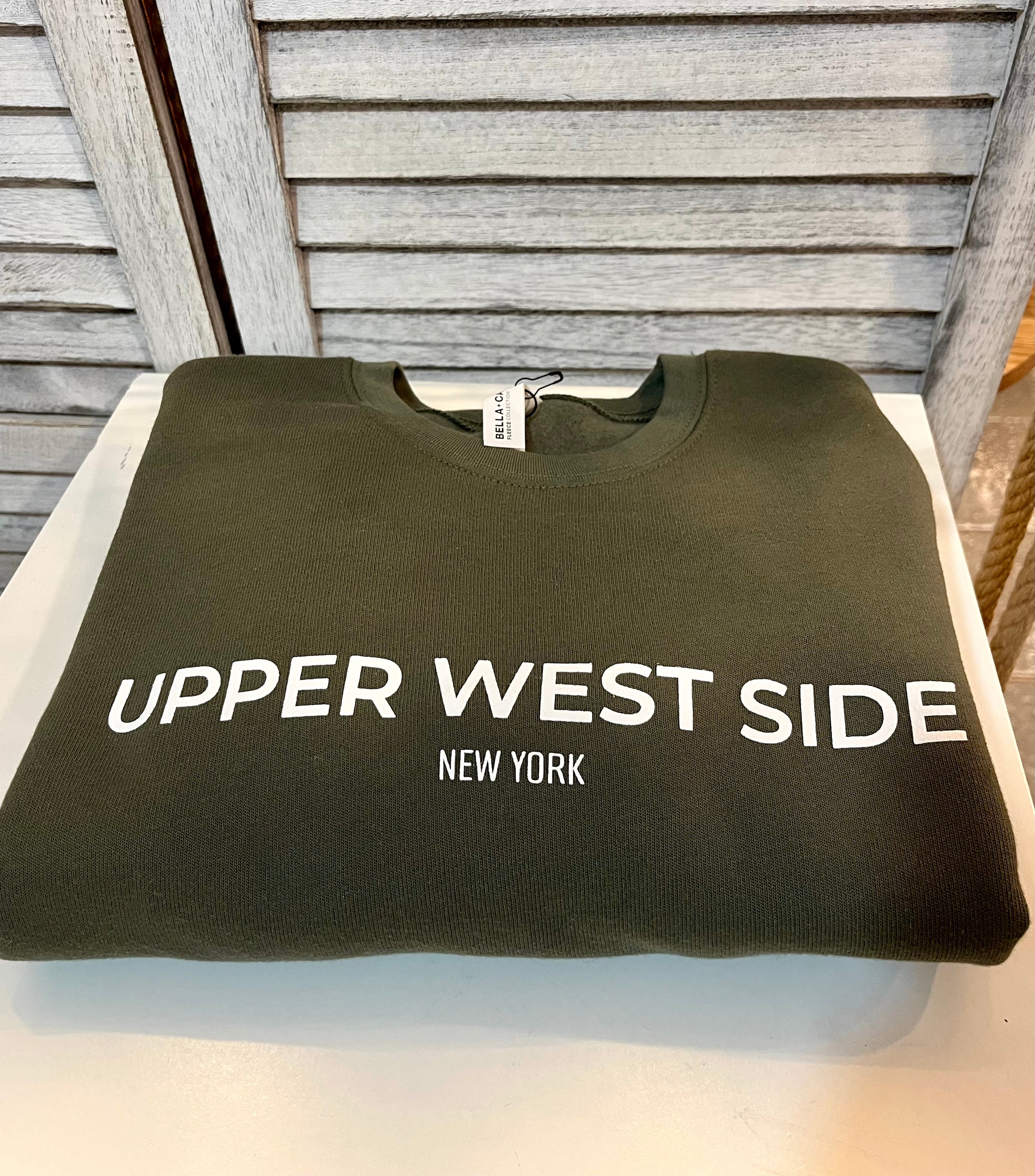 A dark green crew neck sweatshirt with the words Upper West Side printed on the front