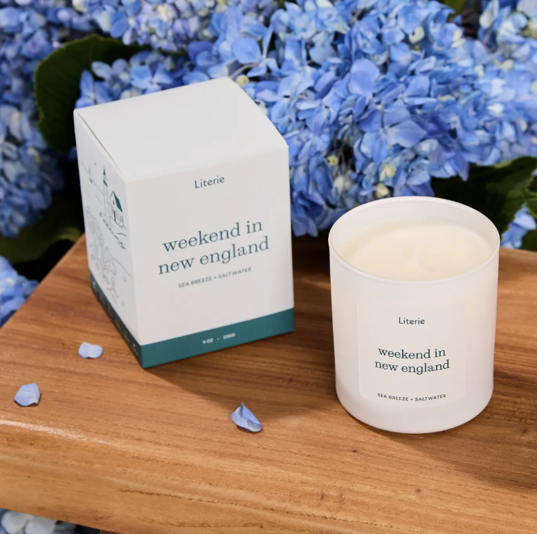Candle and packaging labeled 'weekend in new england' , sea breeze and saltwater scented literie candle