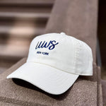 White cap with blue text that says UWS on a textured corduroy hat